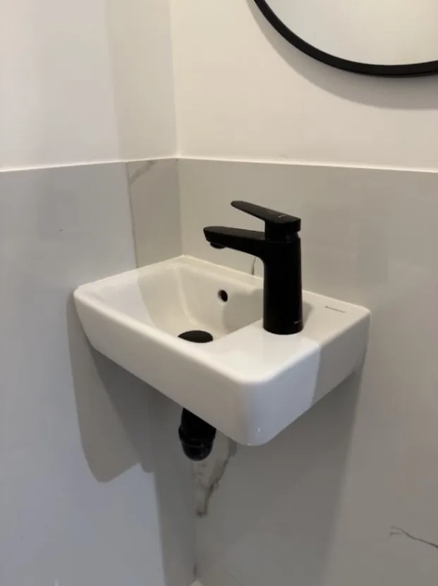 Lavabo et mitigeur noir installés en salle d’eau